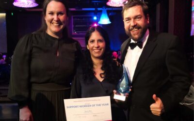 Sonia stands in the middle next to Laura and Adrian, as she holds her award for support worker of the year