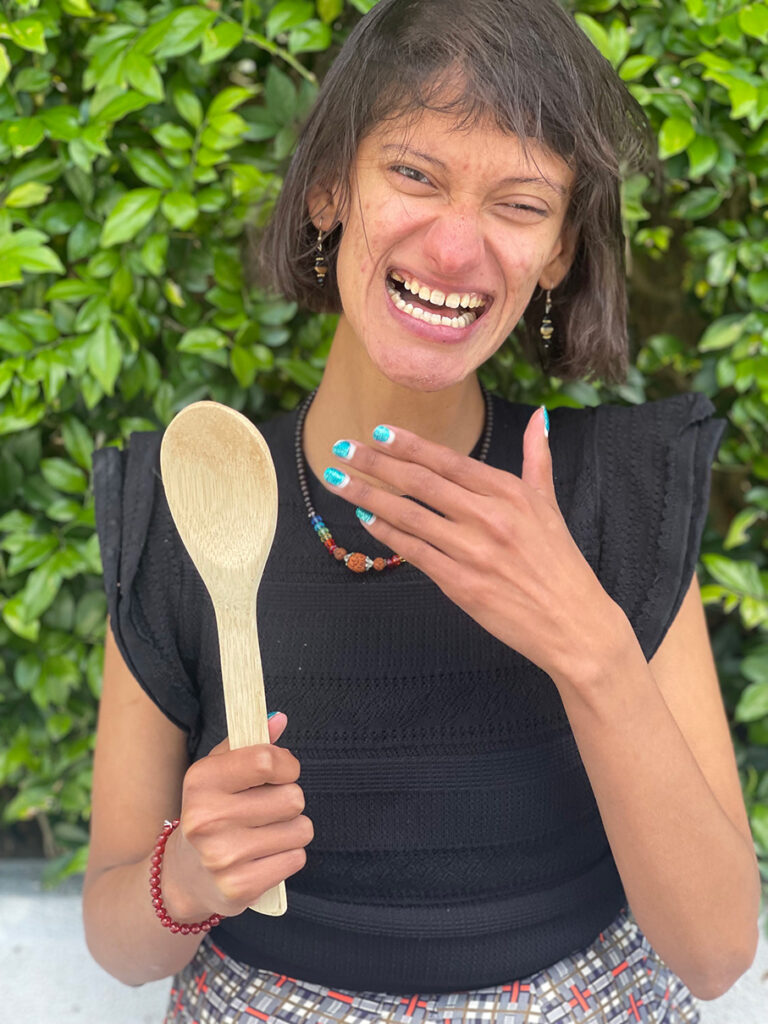 photo of Natesha, Avenue Entreprenuer holding a wooden spoon and laughing in front of camera